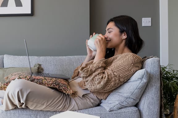 a woman sitting on a couch with a laptop