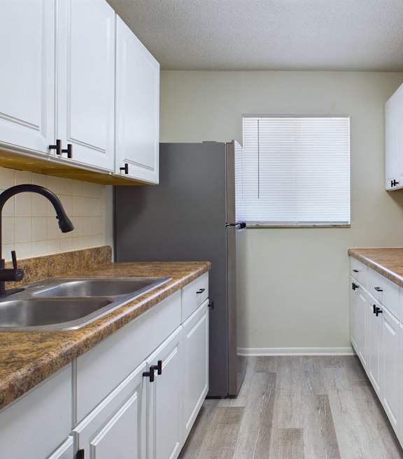 A kitchen with white cabinets and a black stove top oven.