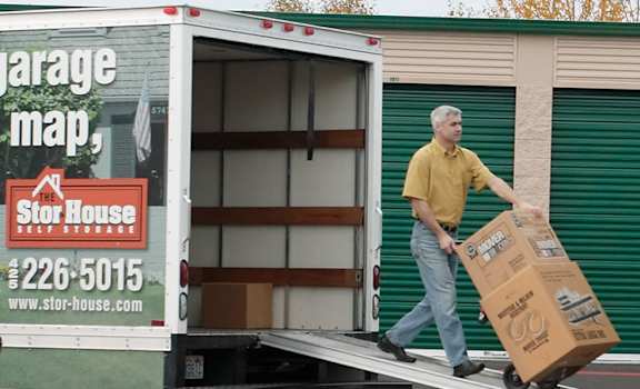 A woman is walking towards a storage unit entrance.