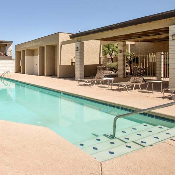 A swimming pool in a backyard with a house in the background.