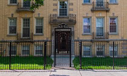 a large brick building with a black fence in front of it