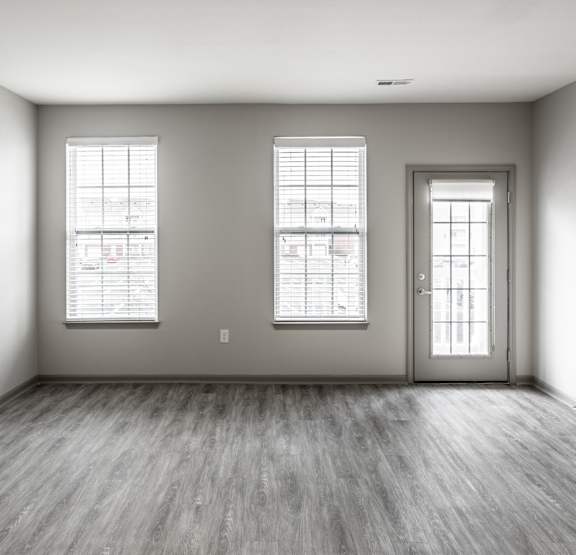 an empty living room and kitchen with a counter top and a refrigerator and microwave at Bella Vista Apartments in Fishers, IN 46038