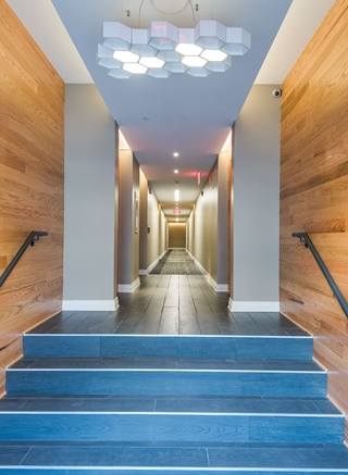 A long hallway with wooden walls and steps leading to the end.
