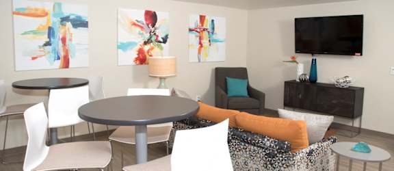 community room with high top seating, a couch and a tv