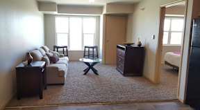 A living room with a couch, chair, and a table.
