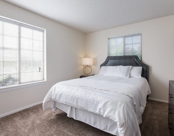 a bedroom with a bed with pillows and two lamps at Heritage Park apartments and townhomes in Minneapolis, MN