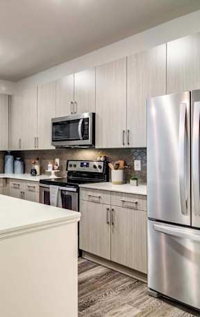 A modern kitchen with a white island and stainless steel appliances.
