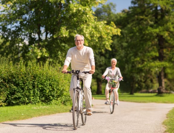 a man and a woman riding bikes on a park