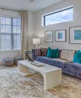 A living room with a grey couch and a white coffee table.