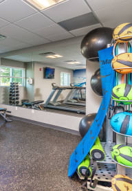 a gym with exercise equipment and weights in the corner of a room
