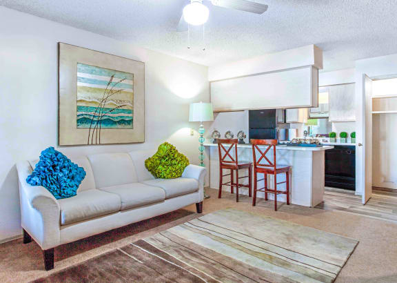 a living room filled with furniture and a ceiling fan
