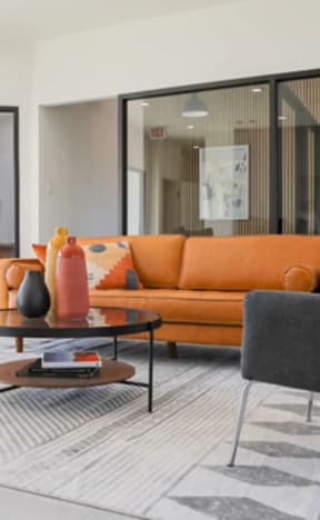 a living room with a orange couch and chairs