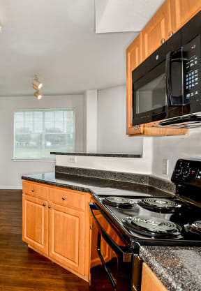 a kitchen with granite countertops and black appliances at Cypress Legends, Fort Myers, 33905
