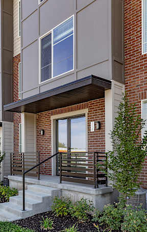 A row of modern townhouses with brick and siding exteriors.