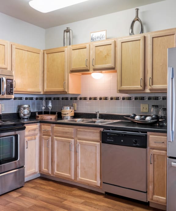 a kitchen with stainless steel appliances and wooden cabinets