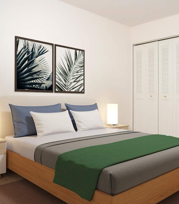 A bedroom with a bed, two lamps, and a painting on the wall.