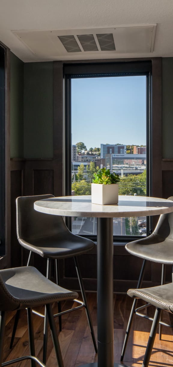 a dining area with chairs and a table in front of a window