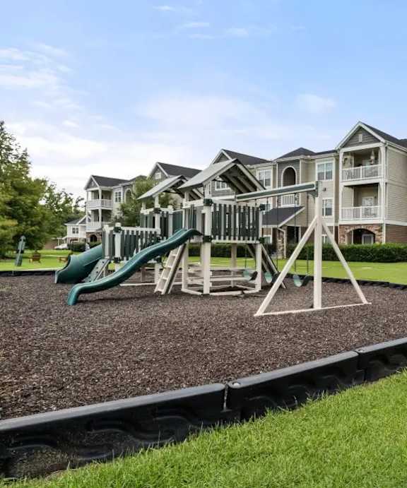 a childrens playground with slides and a swing set at Uphill Flats, Decatur, 30032