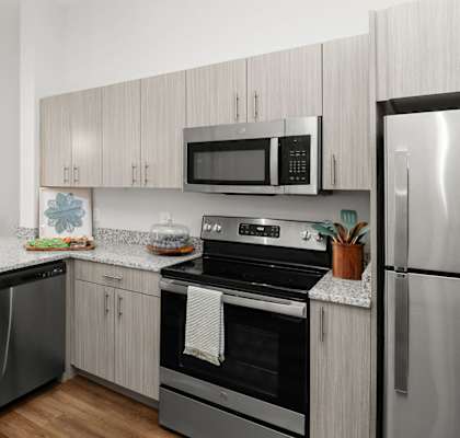 A modern kitchen with stainless steel appliances and wooden cabinets.