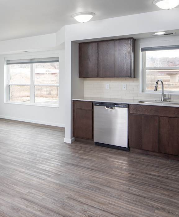 A kitchen with a sink, stove, and cabinets.