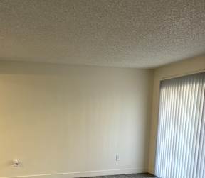A white door is in a room with a grey wall.