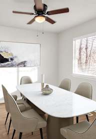 A dining room with a white table and chairs.