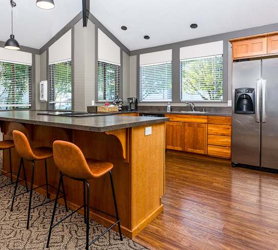 A kitchen with a long island and chairs.