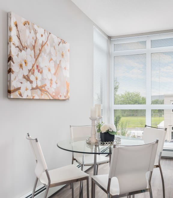 an apartment living room with a glass table and chairs and a couch
