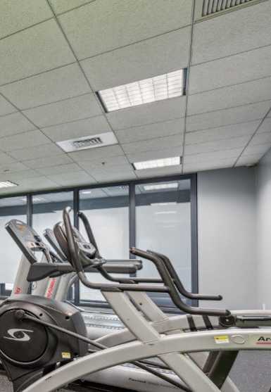 a room filled with cardio equipment and a flat screen tv at Residences at Manchester Place, Manchester, New Hampshire