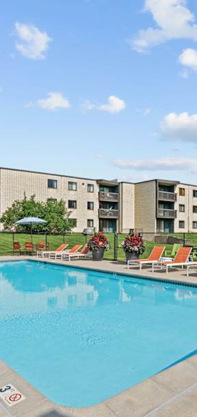 A pool with chairs around it and a blue sky with clouds at Oakwood, Plymouth, MN, 55447