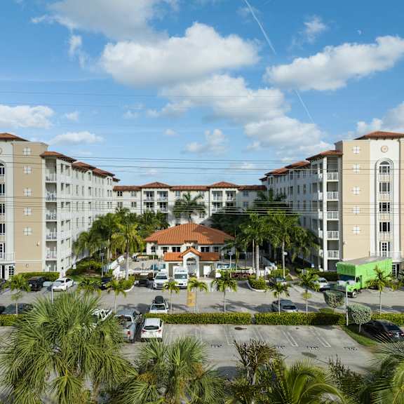 A large apartment complex with a parking lot in front.