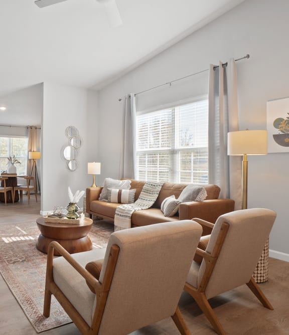 a living room with a couch and chairs and a tv