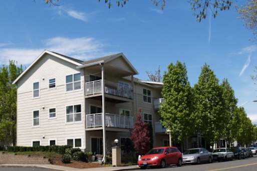 A modern building with a parking lot in front of it.