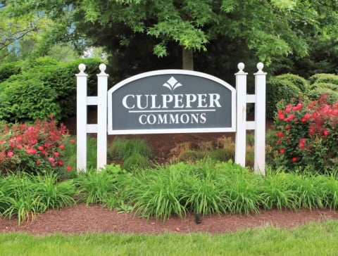 Community sign in the middle of a flower bed.