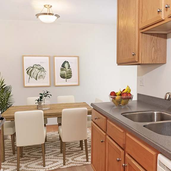 A kitchen with a table and chairs and a fridge.