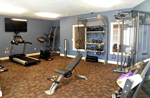 Fitness center with cardio equipment, weight machines, free weights, and television