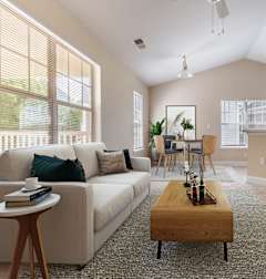 A living room with a white couch, a wooden coffee table, and a flat-screen TV.