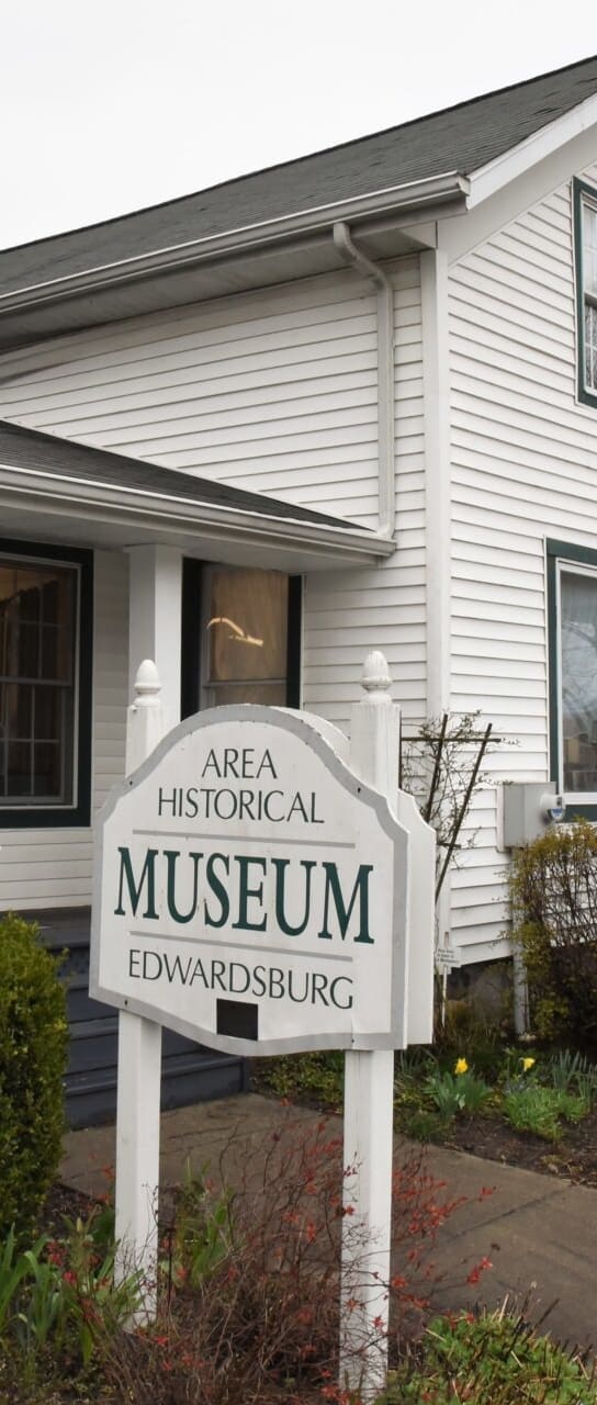 a museum sign in front of a white house