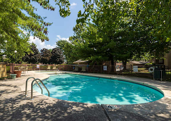 A view of the poolside at Skyler Ridge Apartments, offering a tranquil setting with lounge chairs and refreshing water.