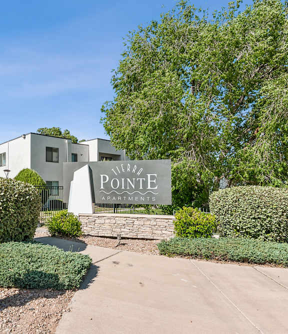 A sign that says Pointe Apartments is in front of a building.