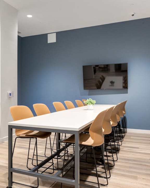 A conference room with a long table and chairs.