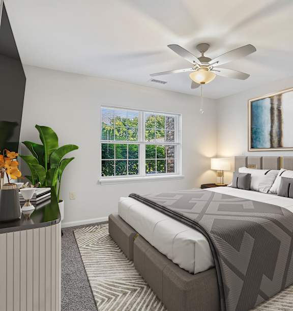A living room with a grey sofa, a yellow chair, a wooden cabinet, a glass coffee table, and a ceiling fan.at Glenmont Abbey Village, 55+ Apartments, New Jersey, 12077