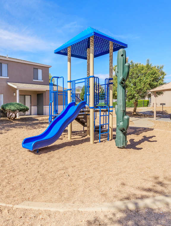 A playground with a blue slide and a green slide.