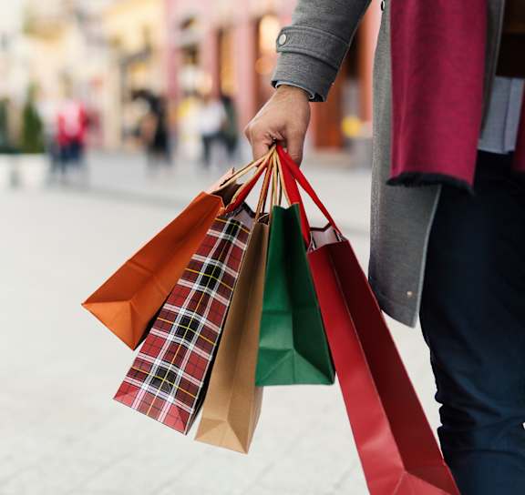 A person is holding shopping bags in their hand.