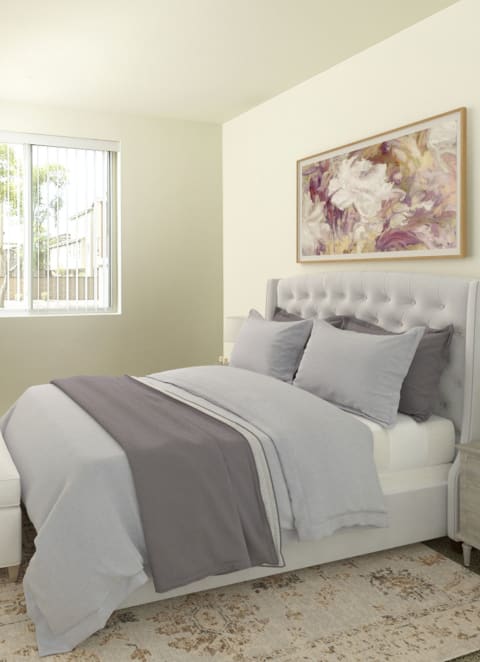 a living room with a white couch and two white chairs with blue and white pillows at The Addie at Metro Center 55+ Apartments, Aurora