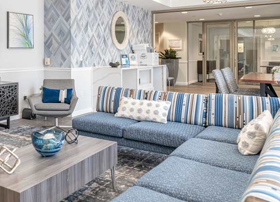 Parkside Commons community room with a grey armchair, a wooden coffee table, and a blue sofa.