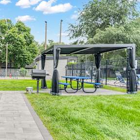 A park with a walkway, benches, and a bike rack.