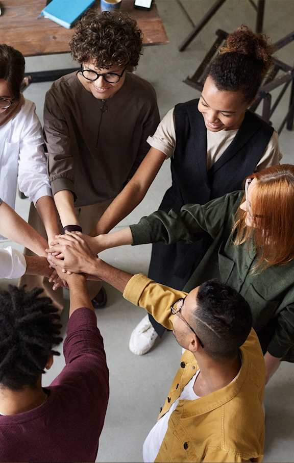 A group of people standing in a circle with their hands joined together.at Convent Gardens Apartments, St. Louis, MO, 63108