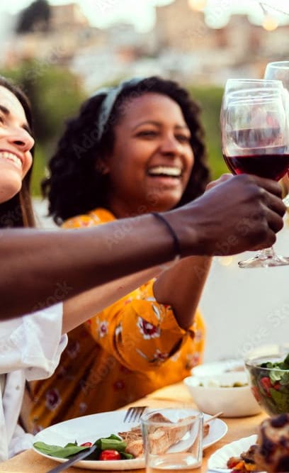 group of friends making a toast over a dinner table