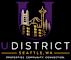 The image is a logo for U District Seattle, WA, featuring a stylized letter "U" with a cityscape and a space needle.